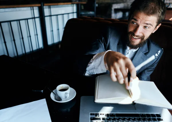 Homme d'affaires assis dans un café devant un ordinateur portable avec une tasse de café style de vie de la technologie de travail — Photo