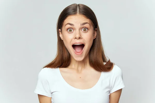 Emotionale Frau mit weit geöffnetem Mund in weißem T-Shirt brünett — Stockfoto