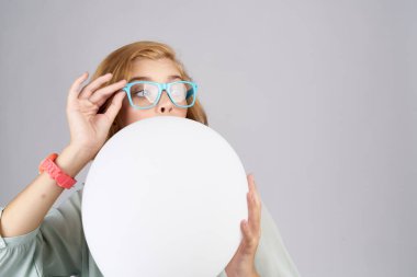 Modaya uygun bir kadın. Elinde pembe bir saat var.