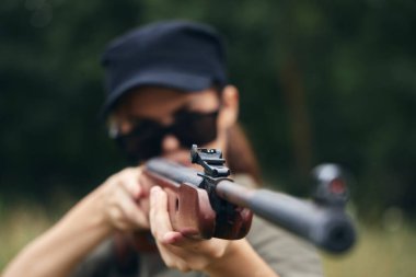 Kadın asker namlu mendili ile yeşil yaprakları avlıyor. 