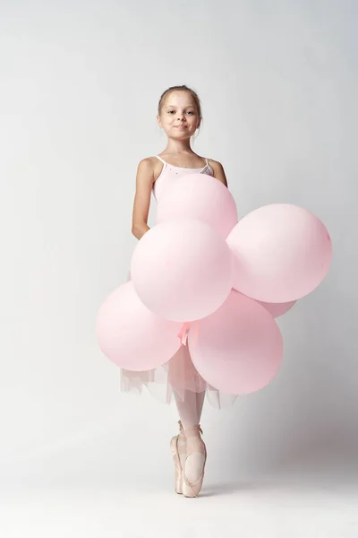 Ballerina meisje in kostuum met ballonnen in handen tutu pointe schoenen dans — Stockfoto