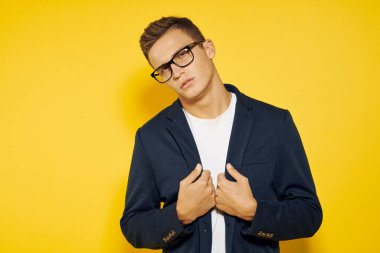 İş yerindeki iş adamı gözlüklü ve sarı arka planda ceketli telefon çalışanı modeli hakkında konuşuyor.