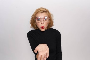 Gözlüklü sevimli sarışın, makyajlı, siyah ceketli açık renk arka plan duyguları olan.