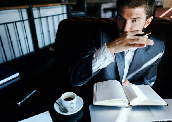 Uomo d'affari seduto in un caffè di fronte a un computer portatile con una tazza di caffè lavoro tecnologia stile di vita — Foto Stock