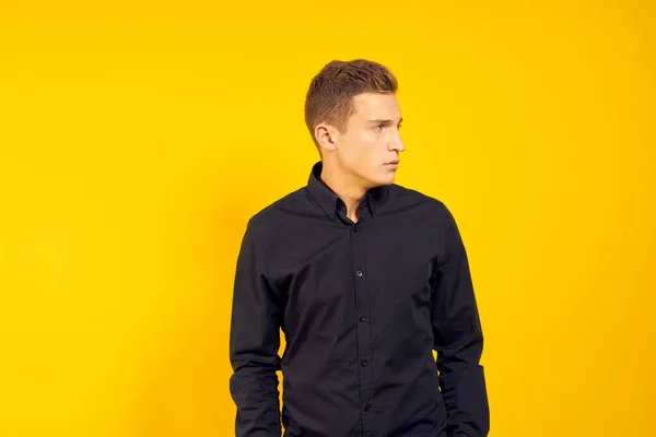 Uomo emotivo in camicia nera stile di vita giallo sfondo isolato — Foto Stock