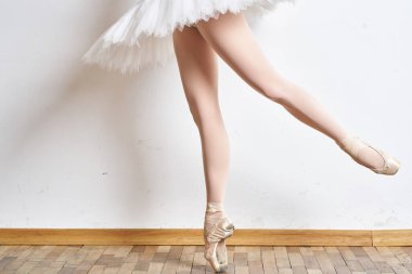 Beyaz etekli, zarif danslı balerin, şehvetli, hafif arka planda bir siluet canlandırdı.