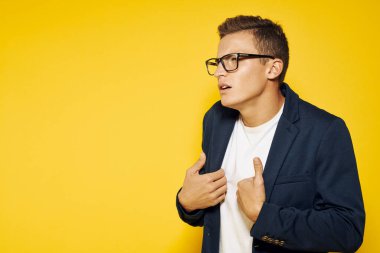 İş yerindeki iş adamı gözlüklü ve sarı arka planda ceketli telefon çalışanı modeli hakkında konuşuyor.