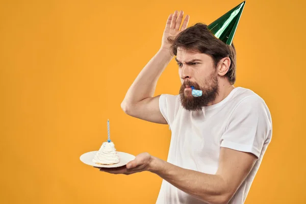 Cumpleañero en una gorra con pastel divertido amarillo fondo partido — Foto de Stock