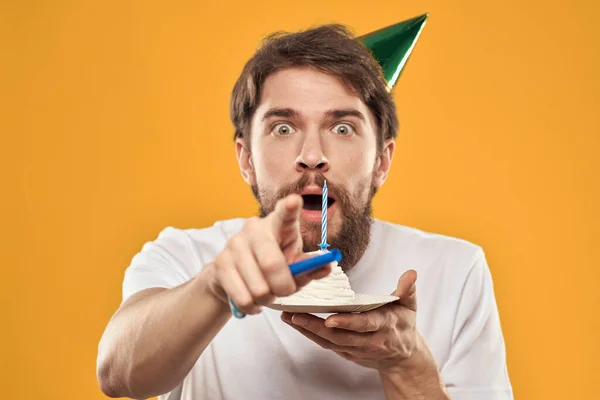 Cumpleañero en una gorra con pastel divertido amarillo fondo partido — Foto de Stock
