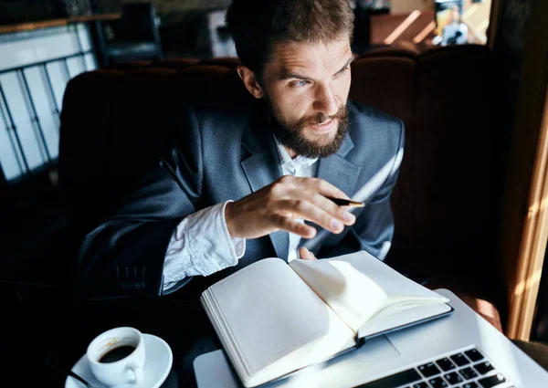 Homme d'affaires assis dans un café devant un ordinateur portable avec une tasse de café style de vie de la technologie de travail — Photo