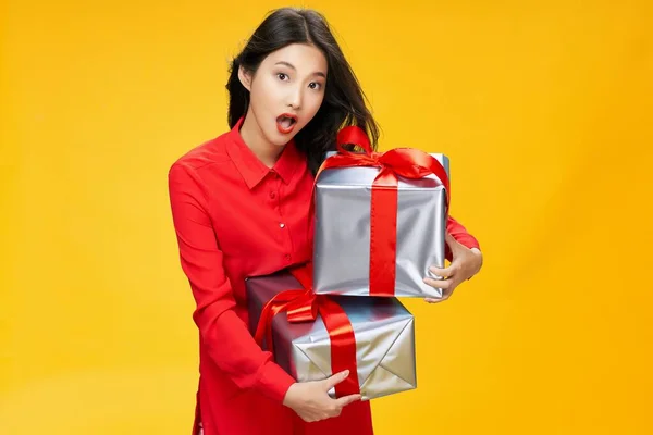 Nő ajándékokkal Karácsonyi ünnep születésnap szórakozás ünnep sárga háttér — Stock Fotó