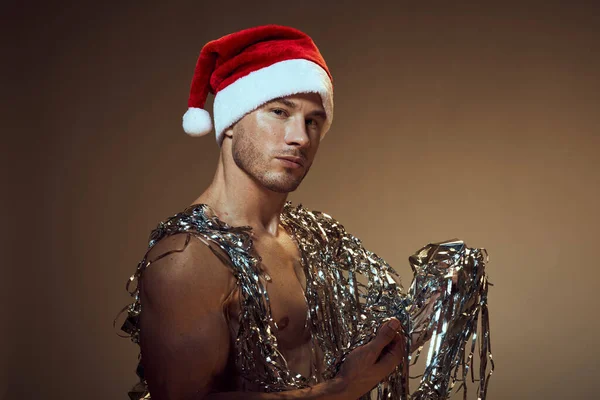 Man bodybuilder christmas decoration santa hat gift — Stock Photo, Image