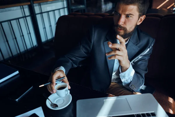 Homme d'affaires assis dans un café devant un ordinateur portable avec une tasse de café style de vie de la technologie de travail — Photo