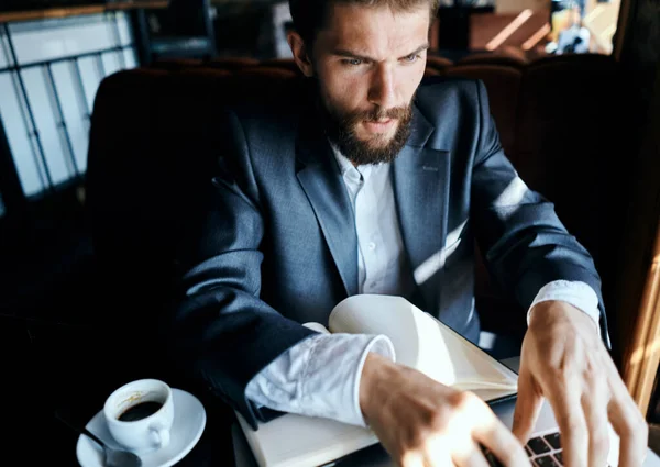 Homme d'affaires assis dans un café devant un ordinateur portable avec une tasse de café style de vie de la technologie de travail — Photo