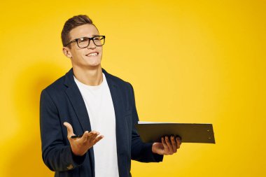 İş yerindeki iş adamı gözlüklü ve sarı arka planda ceketli telefon çalışanı modeli hakkında konuşuyor.