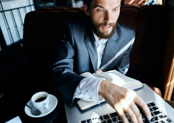 Homme d'affaires assis dans un café devant un ordinateur portable avec une tasse de café style de vie de la technologie de travail — Photo