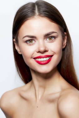 Kadın portresi. Çıplak omuzlar. Cazibeli, yakından gülümseme. 