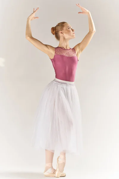 Nő balerina -ban pointe cipő és egy tutu egy könnyű háttér pózol lábak tánc modell — Stock Fotó
