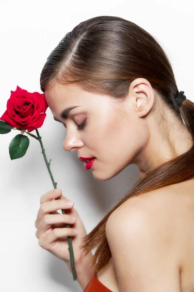 Meztelen nő, csukott szemmel egy rózsát tart az arca mellett. — Stock Fotó