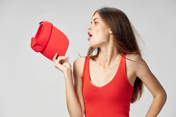Жінка дивиться на бік червоної шапки в руці футболка обрізана вид — стокове фото