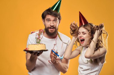 Erkek ve kadın doğum günü şenlikli pasta sarı arka plan ve başlıklar