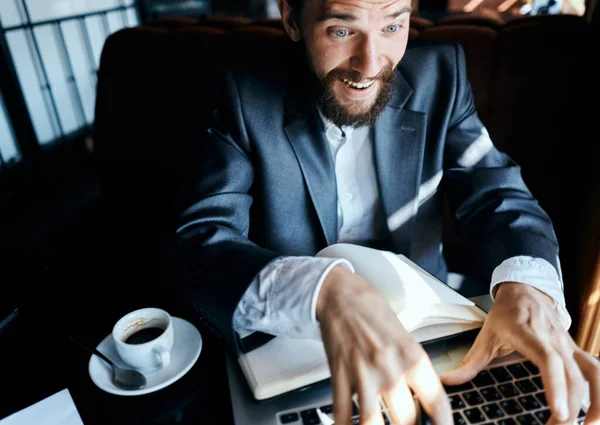 Homme d'affaires assis dans un café devant un ordinateur portable avec une tasse de café style de vie de la technologie de travail — Photo