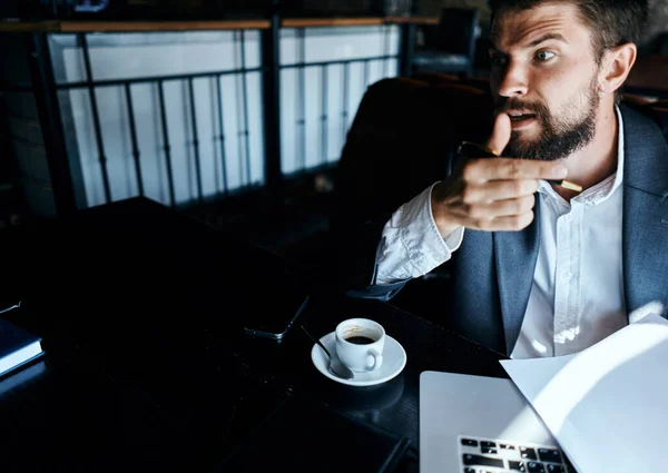 Homme d'affaires dans un costume de café devant les émotions de l'ordinateur portable documents officiels technologie — Photo