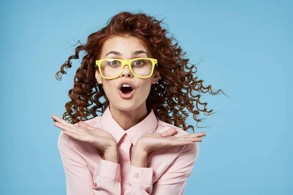 Mulher com cabelo encaracolado camisa rosa óculos amarelos olhar surpreso cortado — Fotografia de Stock