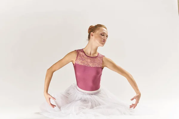 Kobieta baletnica w pointe buty i w tutu na jasnym tle stwarza pozowanie nogi taniec model — Zdjęcie stockowe