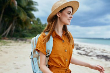 Sırtında sırt çantası ve şapkası olan bir kadın. 