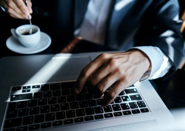 Uomo d'affari in un caffè al tavolo di fronte a un computer portatile di lavoro una tazza di caffè al tavolo tecnologia di comunicazione — Foto Stock