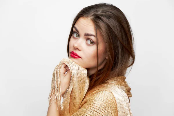 Altın eşarplı bir kız. Yüzündeki üzgün ifade. Kırmızı dudaklar. 