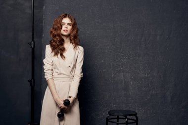 Stüdyo bej elbiseli güzel bir kadın şık bir yaşam tarzı var.