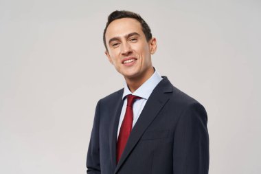 Klasik takım elbiseli bir adam kameraya gülümser.