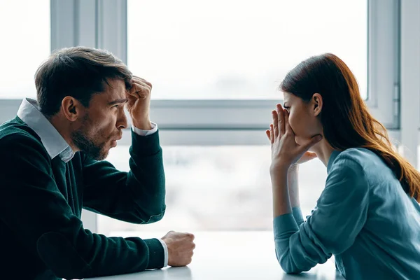 Uomo e donna seduti a tavola sconvolto aspetto europeo — Foto Stock