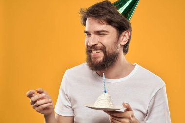 Sarı arka planda tatil günü şapkalı bir adam.