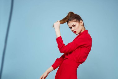 Mavi arka planda parlak elbiseli çekici bir kadın elleri ve kırmızı dudaklarıyla jestler yapıyordu.