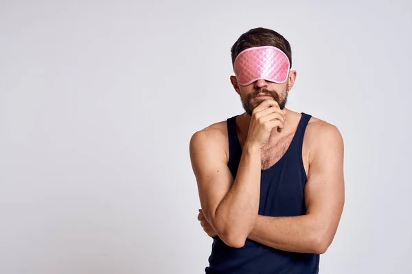ピンクの睡眠マスクとグレーの背景に黒いTシャツを持つ男クロップドビュー — ストック写真