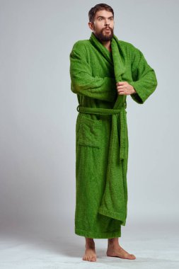 emotional man in a green robe on a light background in full growth fun emotions model clipart