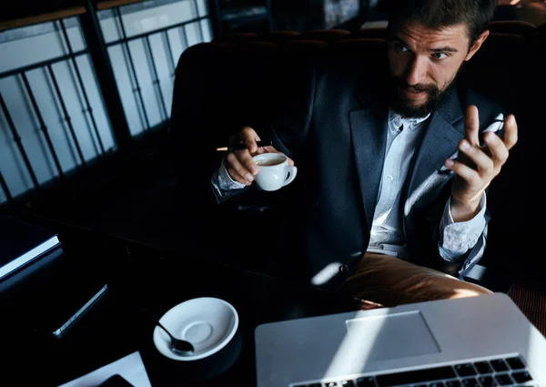 Homme d'affaires assis dans un café devant un ordinateur portable avec une tasse de café style de vie de la technologie de travail — Photo