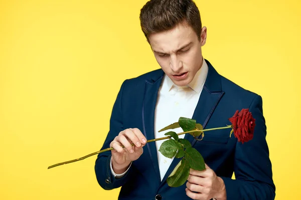 Panowie w klasycznym garniturze na żółtym tle i czerwonej róży romans przycięty widok model portret. — Zdjęcie stockowe