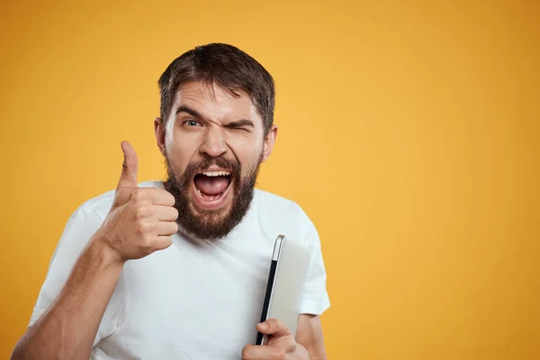 emotional man with laptop on yellow background gesturing with hands cropped view Copy Space