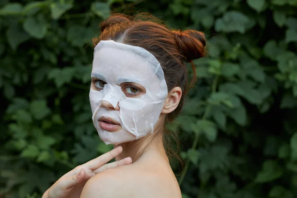 Belle fille masque blanc tient la main près du cou vue de côté soins de la peau — Photo