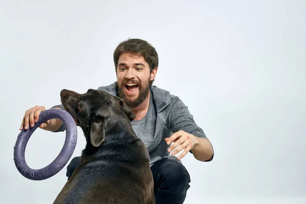 Feliz propietario con mascota negro perro entrenamiento modelo emociones — Foto de Stock