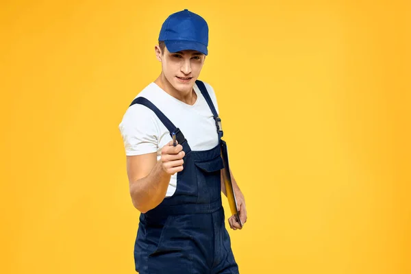 Man in het werken uniforme documenten weergave van diensten bezorgdienst gele achtergrond — Stockfoto