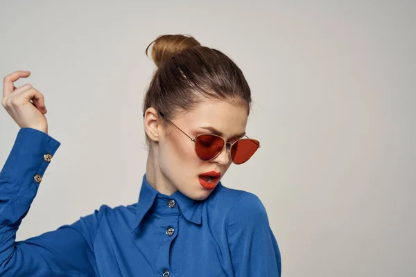 Portret kobiety w okularach przeciwsłonecznych i niebieskiej koszuli na jasnym tle przycięty widok Model Copy Space — Zdjęcie stockowe
