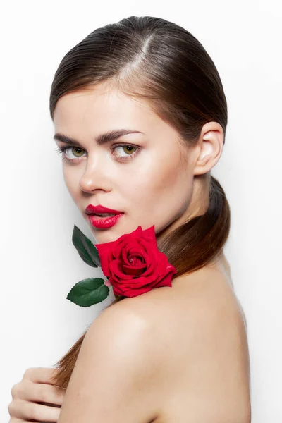 Beautiful woman with rose Looks forward bare shoulders luxury cute face light
