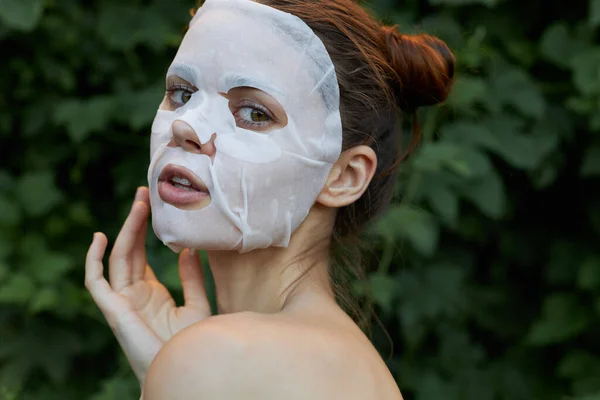 Retrato de una chica mascarilla Vista posterior conmovedora cara con cosmetología de la mano —  Fotos de Stock