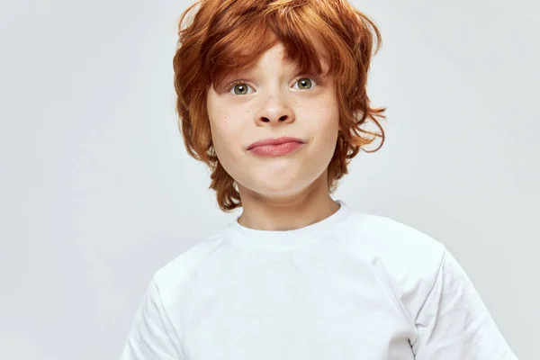 Rojo de pelo chico muecas primer plano blanco camiseta estudio emociones —  Fotos de Stock