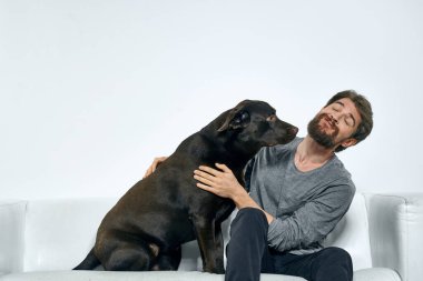 Kanepede evcil köpeği olan bir adam. Arkadaşlarıyla eğleniyor.